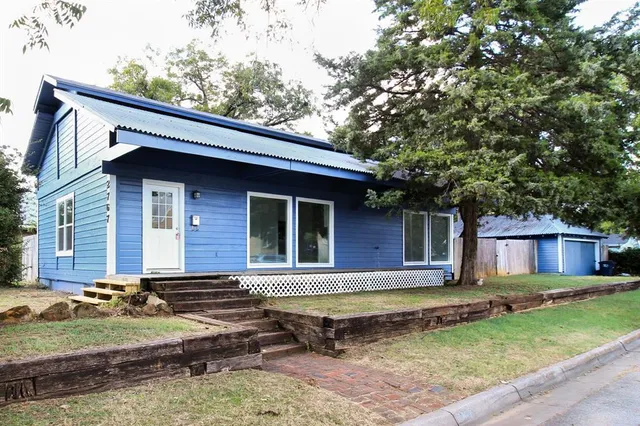 a view of a house with backyard and sitting area