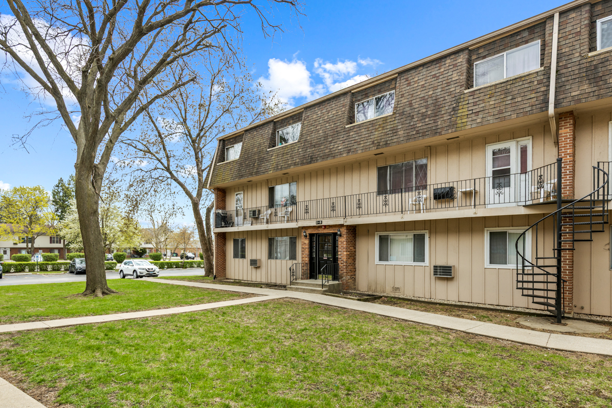 a front view of a building with a garden