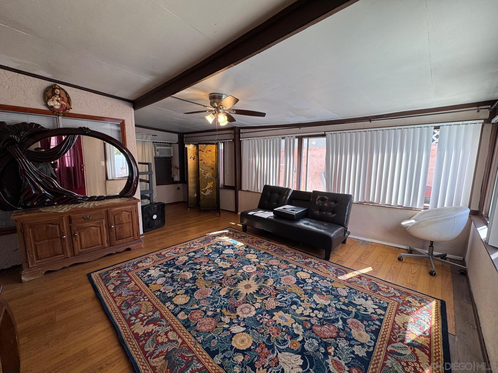 7933 Merrington Place, Unit ROOM FOR R San Diego, CA 92126 - Photo 2 of 4 a living room with furniture rug and a window