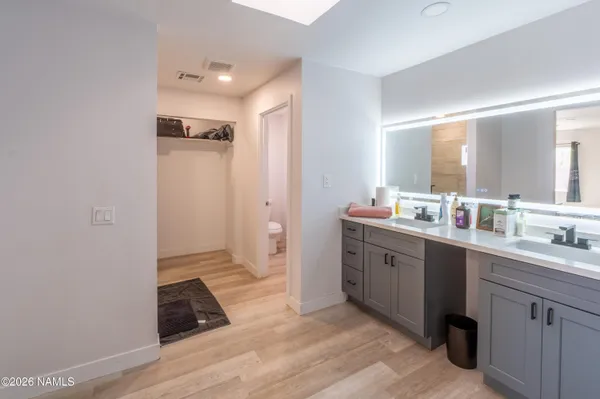 a spacious bathroom with a double vanity sink a mirror and a shower