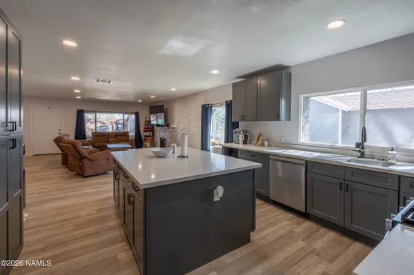 a kitchen with stainless steel appliances granite countertop a sink a stove and a wooden floors