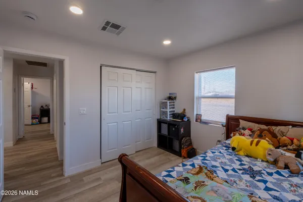 a bedroom with bed and wooden floor