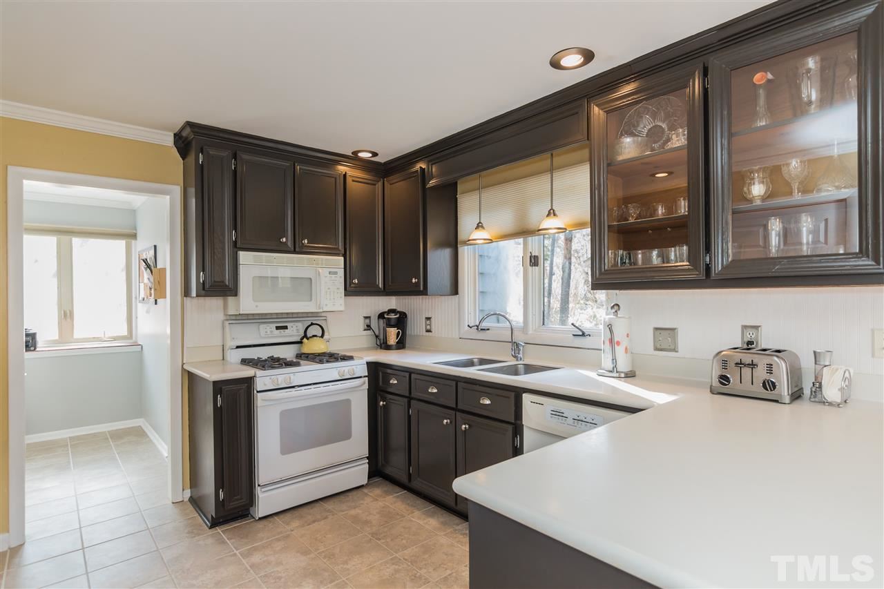 5 Sandstone Ridge Drive Durham, NC 27713 - Photo 11 of 25 a kitchen with a sink a stove and cabinets