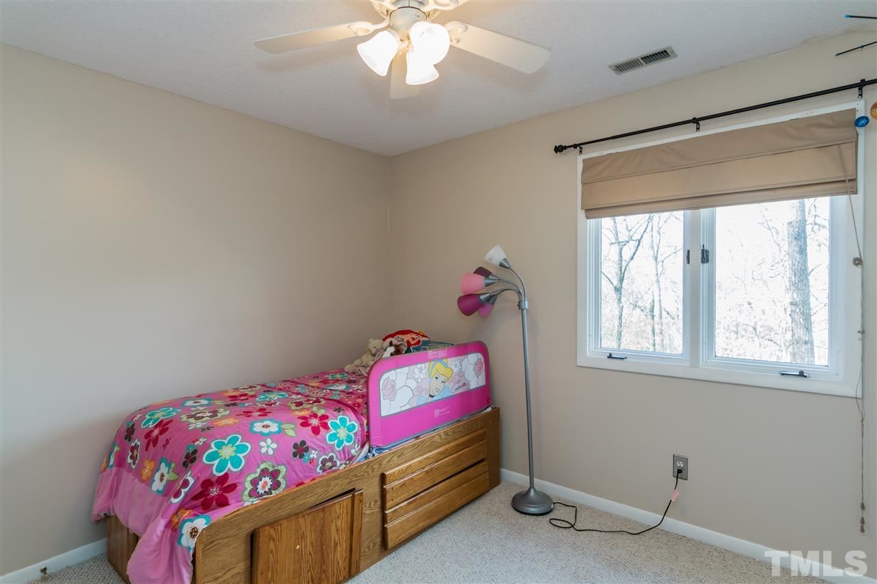 5 Sandstone Ridge Drive Durham, NC 27713 - Photo 16 of 25 a bedroom with a bed and a chandelier