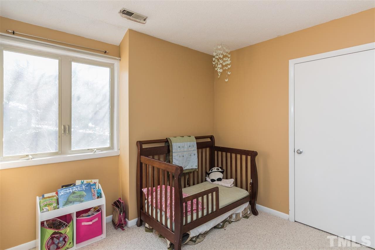 5 Sandstone Ridge Drive Durham, NC 27713 - Photo 18 of 25 a view of a bedroom with window and baby crib