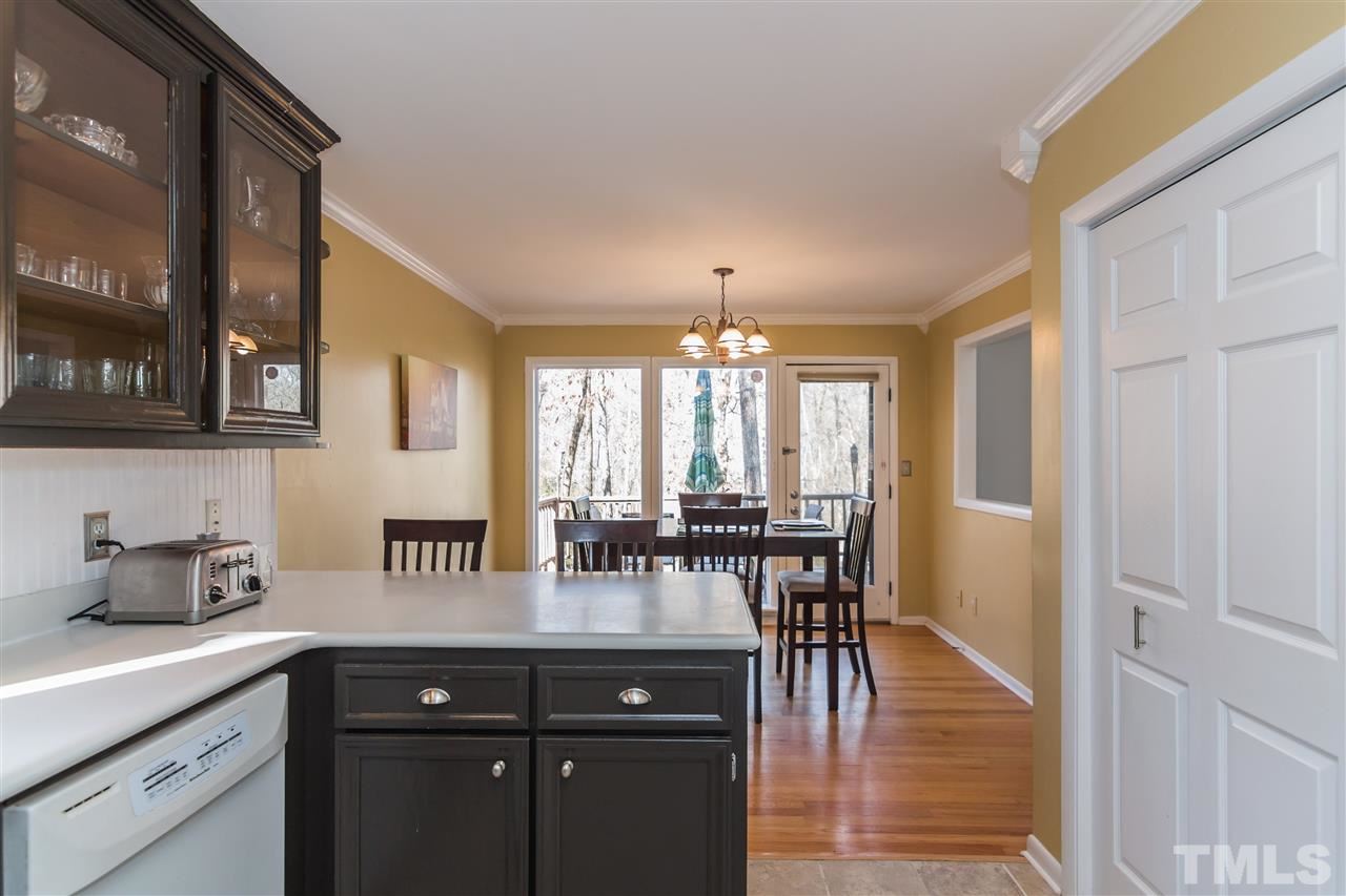 5 Sandstone Ridge Drive Durham, NC 27713 - Photo 9 of 25 a kitchen with stainless steel appliances granite countertop a table chairs in it and wooden floors