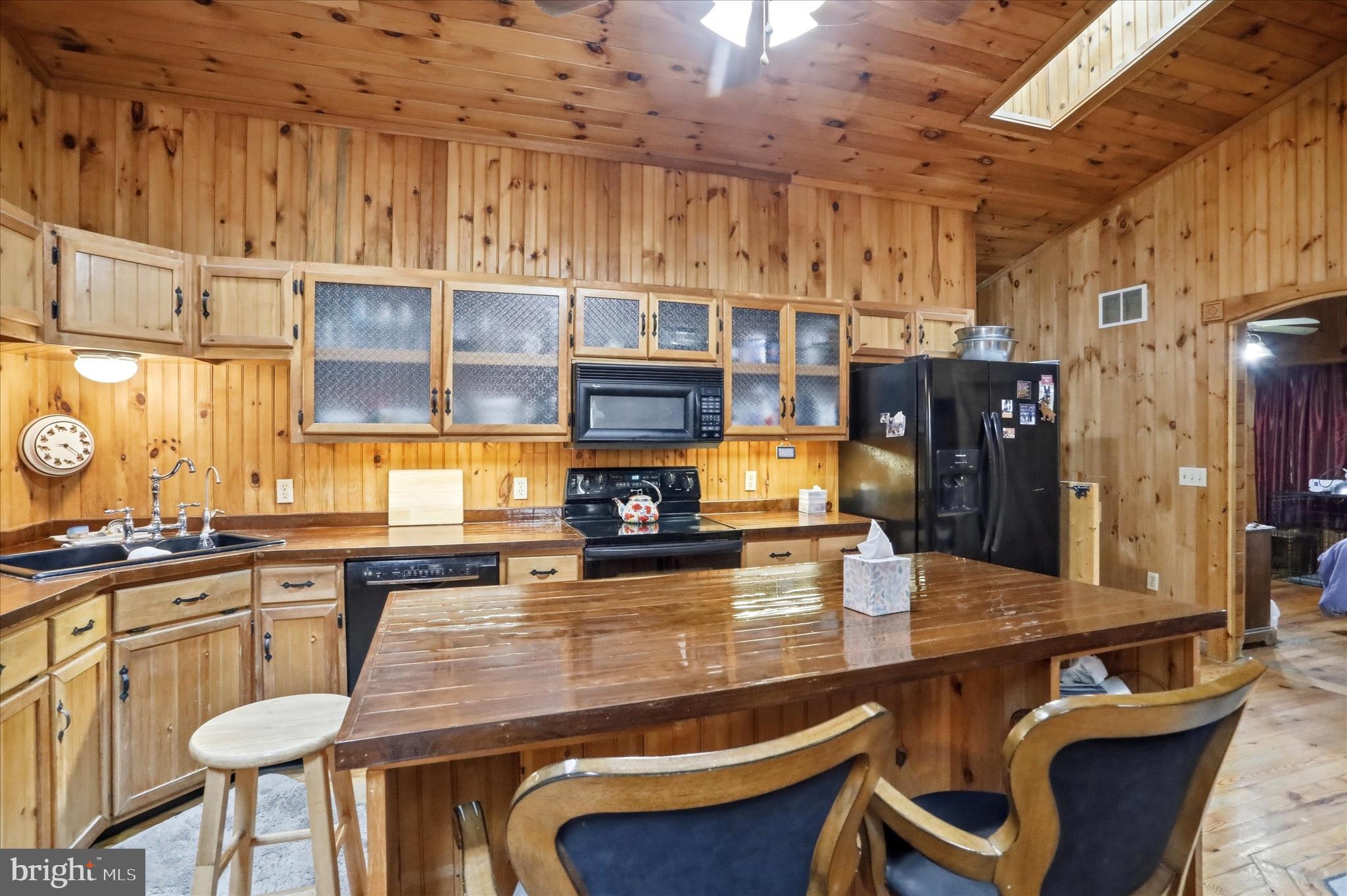 90 Shade Valley Road Rio, WV 26755 - Photo 10 of 41 a kitchen with stainless steel appliances kitchen island granite countertop a table chairs in it and a wooden floor