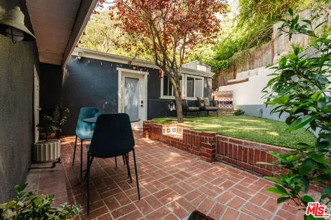a view of house with backyard and outdoor seating