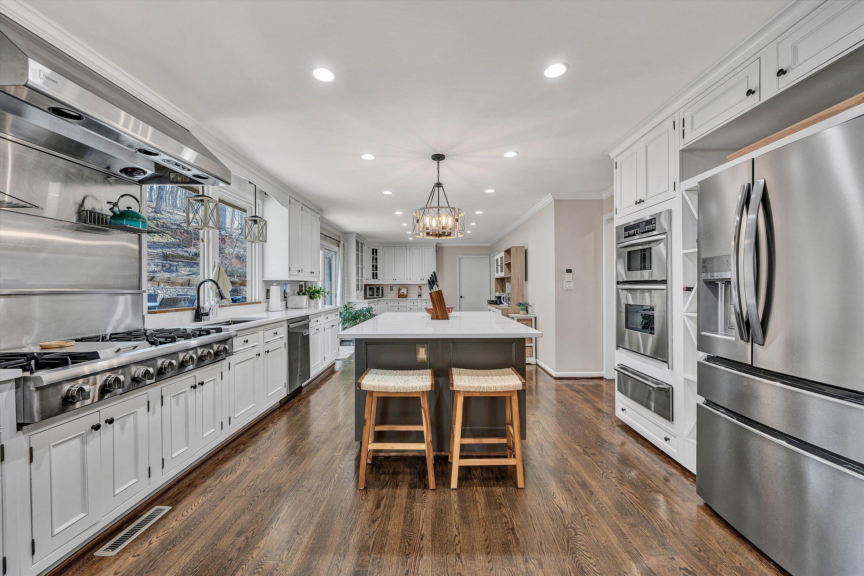 5157 Remington Road Roanoke, VA 24018 - Photo 20 of 63 a kitchen with stainless steel appliances a sink stove a refrigerator and a dining table with wooden floor