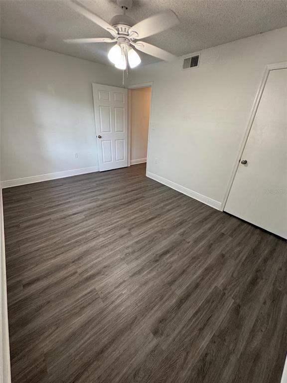 1197 Bentley Road, Unit 3 Leesburg, FL 34748 - Photo 11 of 14 an empty room with wooden floor fan and windows