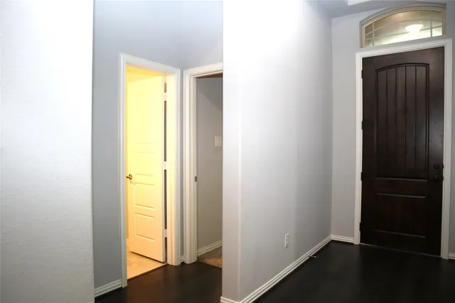 a view of a room with a hallway and wooden floor