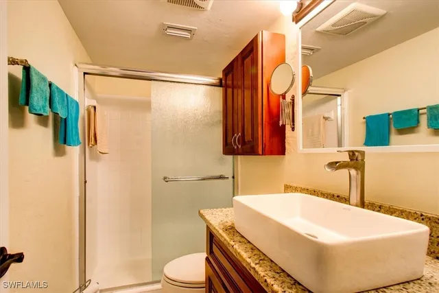 a bathroom with a sink a toilet and shower