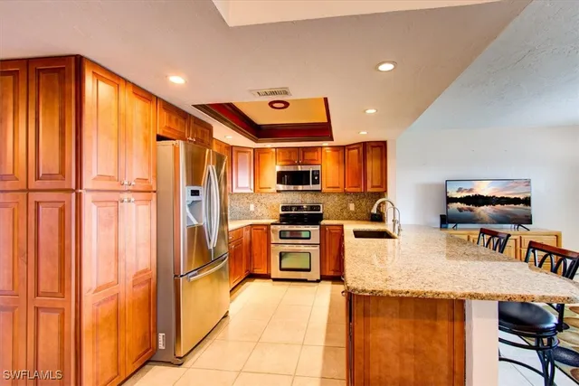 a kitchen with stainless steel appliances granite countertop a refrigerator and a stove top oven