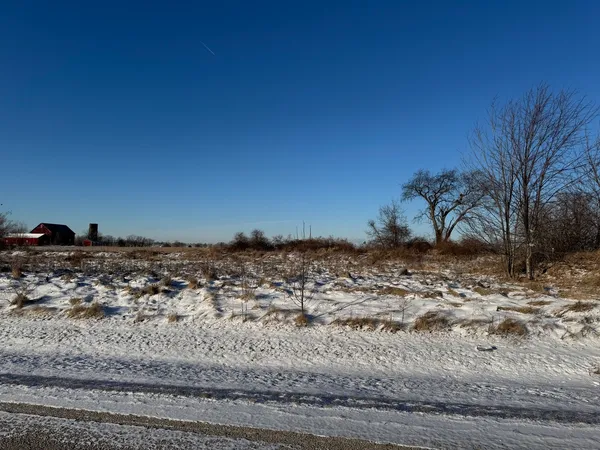 a view of a dry yard with wooden fence