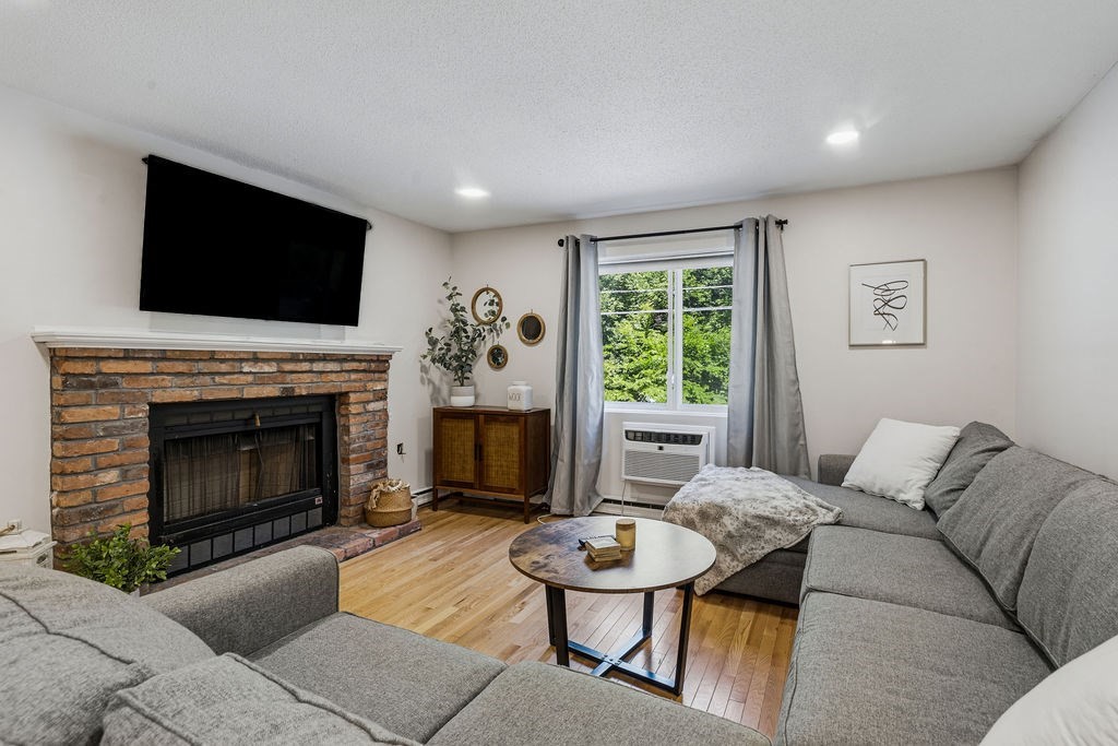 10 Erick Road, Unit 42 Mansfield, MA 02048 - Photo 6 of 33 a living room with furniture a flat screen tv and a fireplace