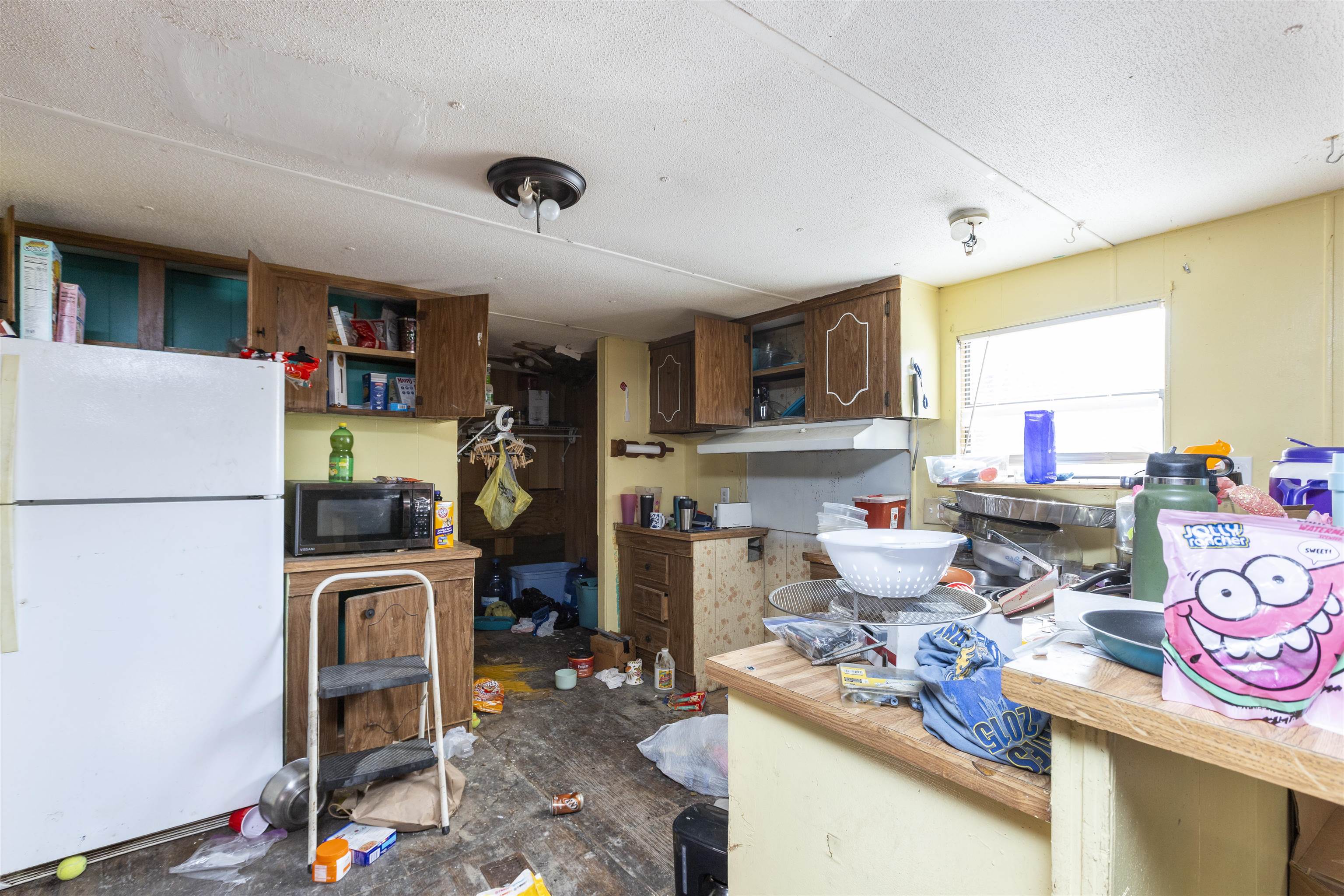 1931 Ryan Road St. Augustine, FL 32092 - Photo 30 of 34 Kitchen featuring freestanding refrigerator, light countertops, black microwave, a textured ceiling, and open shelves