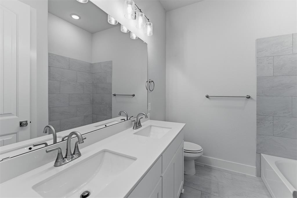 2316 Quartz Street Krum, TX 76249 - Photo 13 of 29 Dual vanity with undermount sinks and brushed nickel faucets, set against a full-width mirror