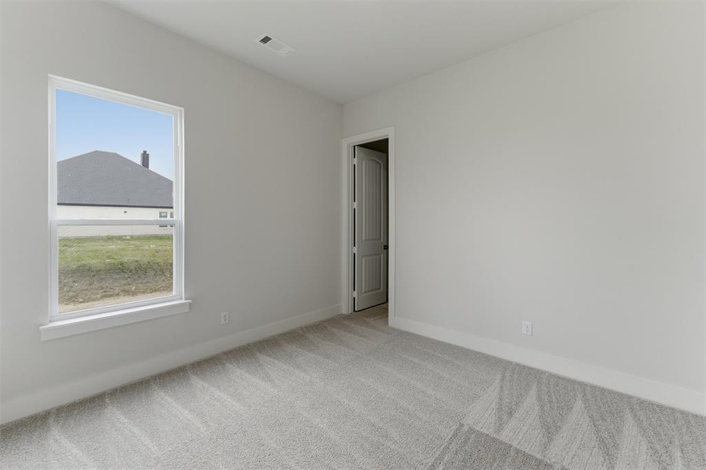 2316 Quartz Street Krum, TX 76249 - Photo 16 of 29 Neutral painted walls complement the patterned gray carpet