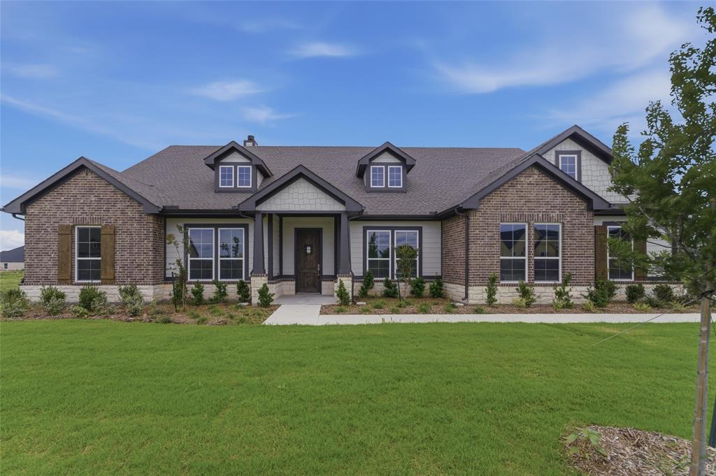 2316 Quartz Street Krum, TX 76249 - Photo 2 of 29 Single-story residence featuring a brick and siding exterior, a dark shingle roof, and multiple gabled dormer windows