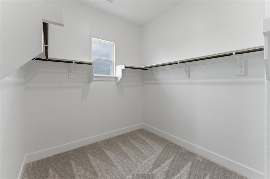 2316 Quartz Street Krum, TX 76249 - Photo 22 of 29 Walk-in closet featuring light gray patterned carpet flooring, white walls, and a single window for natural illumination