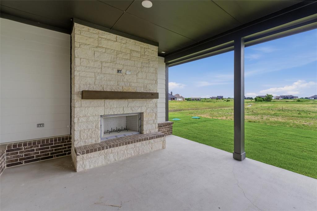 2316 Quartz Street Krum, TX 76249 - Photo 23 of 29 Covered patio featuring an outdoor stone fireplace with a wood mantel