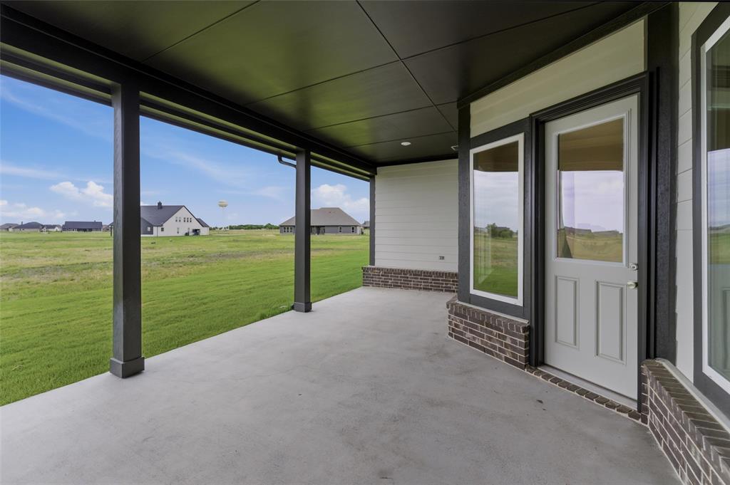 2316 Quartz Street Krum, TX 76249 - Photo 24 of 29 Covered concrete patio featuring dark support columns and a dark soffit ceiling