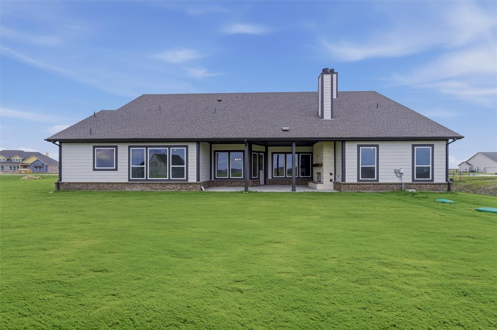 2316 Quartz Street Krum, TX 76249 - Photo 26 of 29 Expansive green lawn surrounds a contemporary residence with a covered patio