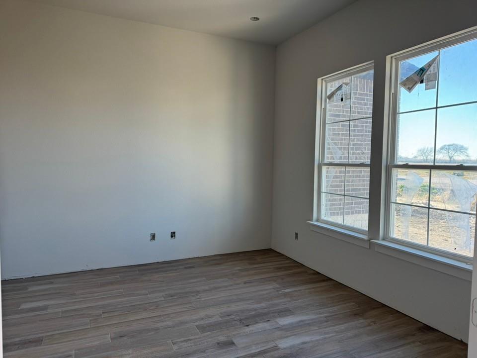 2316 Quartz Street Krum, TX 76249 - Photo 4 of 12 an empty room with wooden floor and windows