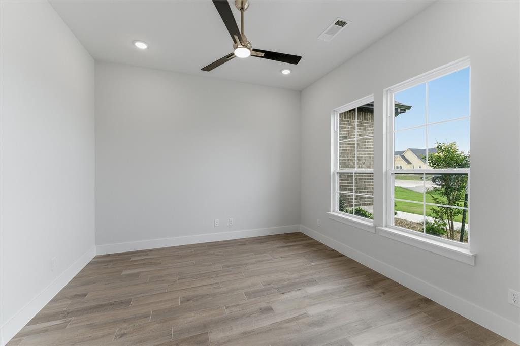 2316 Quartz Street Krum, TX 76249 - Photo 5 of 29 Bright room featuring two windows, wood-finish flooring, a ceiling fan with integrated lighting, and recessed ceiling lights