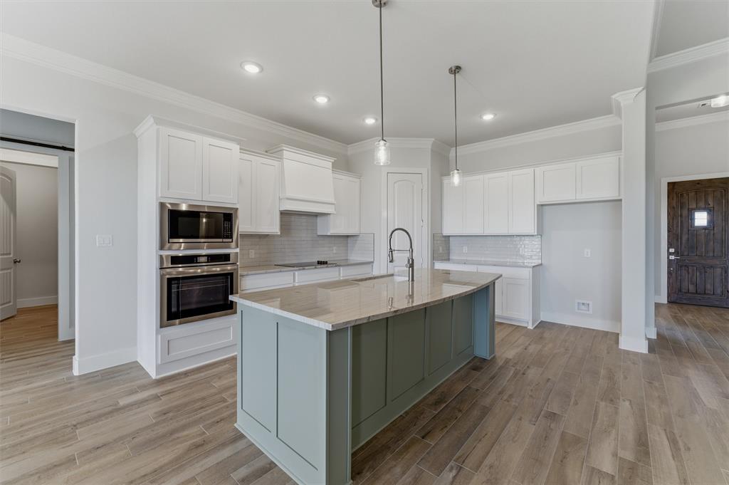 2316 Quartz Street Krum, TX 76249 - Photo 9 of 29 Kitchen featuring a large island with a countertop, integrated sink, and pendant lighting