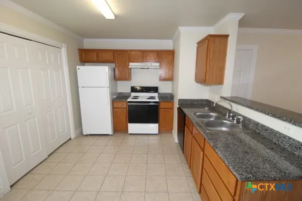 a kitchen with granite countertop a stove and a sink