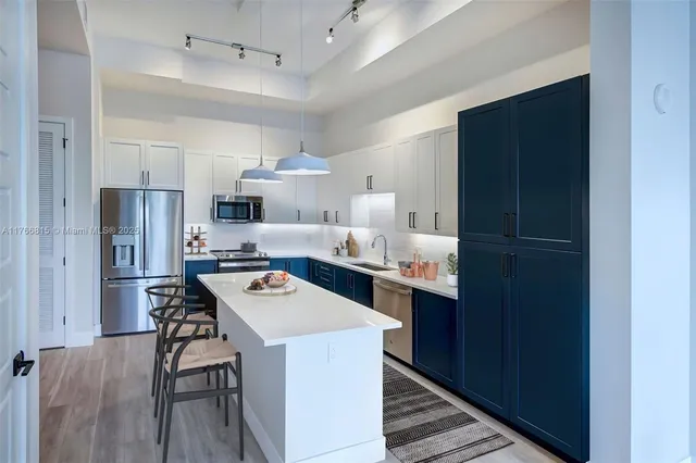 a kitchen with stainless steel appliances a refrigerator a sink dishwasher a stove with wooden cabinets