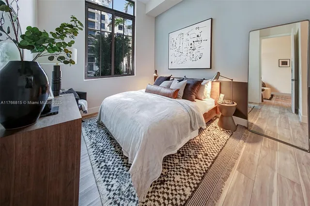 a bed sitting in a bedroom next to a window