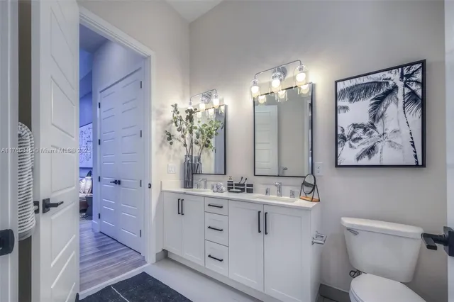 a bathroom with a double vanity sink mirror and toilet