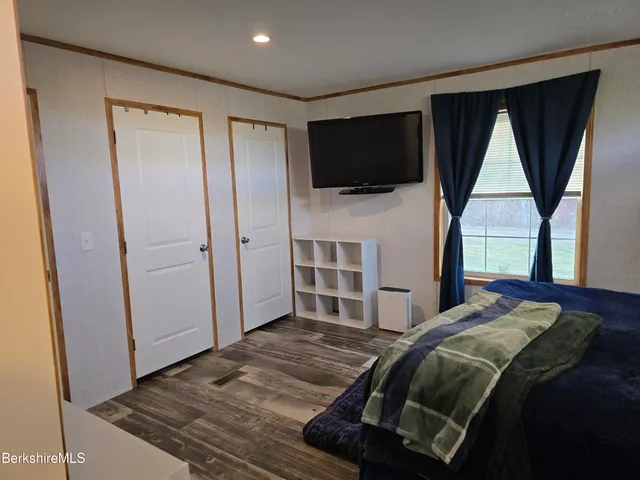 a bedroom with a bed closet and flat screen tv