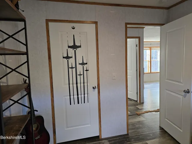 a view of a hallway with wooden floor and entryway