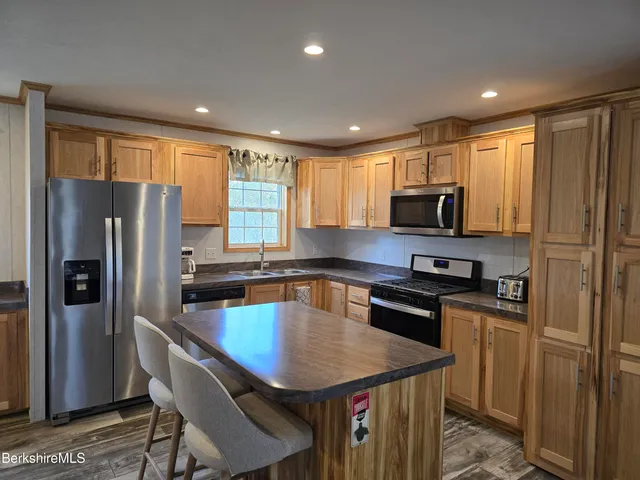 a kitchen with stainless steel appliances granite countertop refrigerator stove microwave and sink