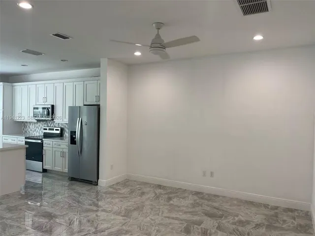 a kitchen with refrigerator and cabinets