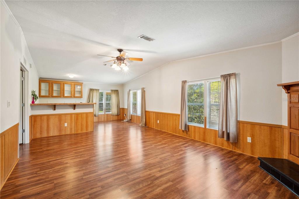 3319 Fox Ridge Boulevard Wesley Chapel, FL 33543 - Photo 11 of 50 a view of an empty room with wooden floor and a kitchen