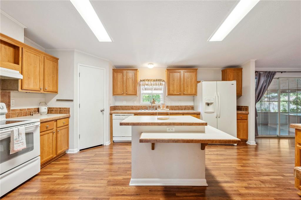 3319 Fox Ridge Boulevard Wesley Chapel, FL 33543 - Photo 19 of 50 a kitchen with stainless steel appliances hardwood floor sink stove and wooden cabinets