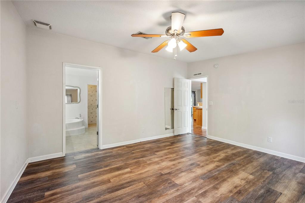 3319 Fox Ridge Boulevard Wesley Chapel, FL 33543 - Photo 25 of 50 a view of an empty room with wooden floor and ceiling fan
