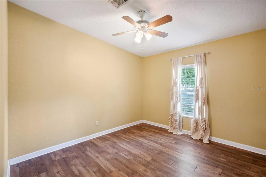 3319 Fox Ridge Boulevard Wesley Chapel, FL 33543 - Photo 29 of 50 an empty room with wooden floor and windows