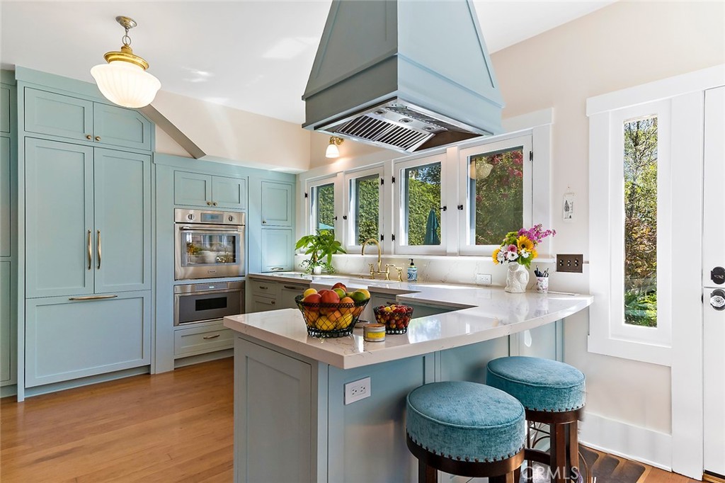 3216 2nd Street Long Beach, CA 90803 - Photo 21 of 62 a kitchen with stainless steel appliances granite countertop a stove a refrigerator a sink a dining table and chairs with wooden floor
