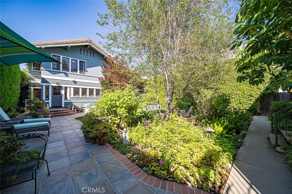 3216 2nd Street Long Beach, CA 90803 - Photo 43 of 62 a yellow house with flower garden in front of it
