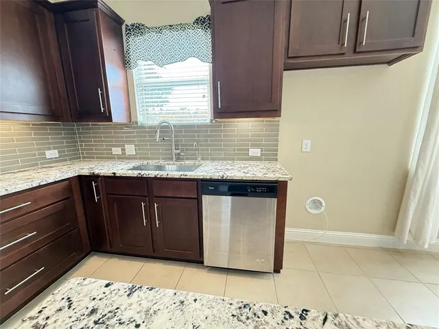 a kitchen with granite countertop a sink and a stove