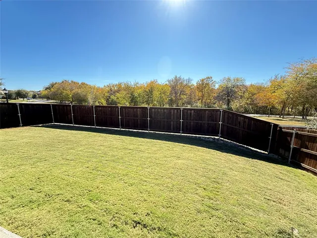 a view of a yard with wooden fence