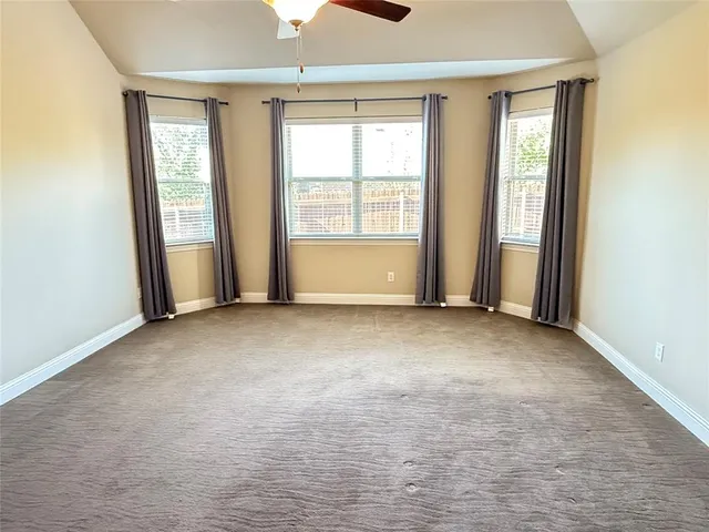an empty room with a ceiling fan and a window