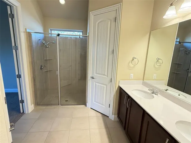 a bathroom with a double vanity sink and large mirror