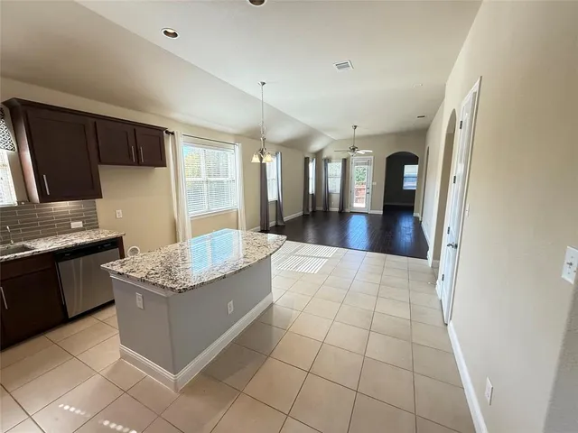 a kitchen with stainless steel appliances granite countertop a sink stove and a refrigerator