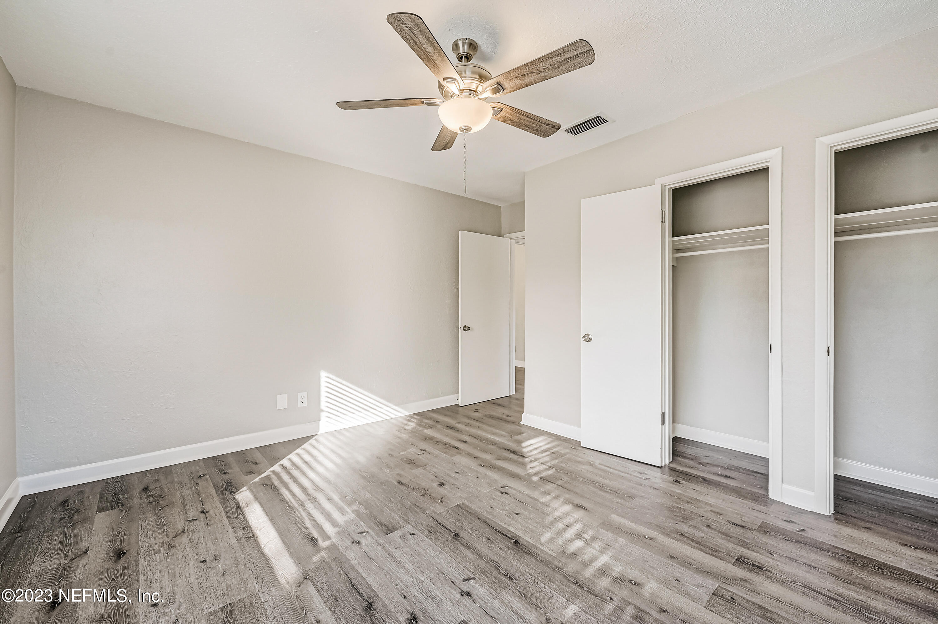 6105 Duke Road Jacksonville, FL 32217 - Photo 17 of 29 an empty room with wooden floor and ceiling fan